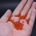 Amber glass seed beads for DIY jewelry making held in hand for size comparison - 4mm / 15g / Orange