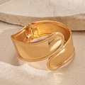 Primer plano detallado del brazalete dorado irregular ancho con acabado pulido brillante - Dorado