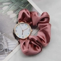 Detail of elegant gold case watch with mauve silk ribbon scrunchie strap on a magazine - Deep Pink