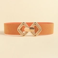 Détail d'une ceinture élastique orange avec boucle géométrique en métal doré et rayures - Style élastique / Orange Perlé