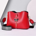 Red crossbody bag with black bow pendant and stylish black and white chevron strap - Red