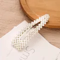 Elegante pinza para el cabello ovalada con perlas blancas sobre fondo minimalista - Plateado