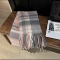 Close-up detail of soft pink and grey plaid scarf texture with long tassels on wooden chair - Baba Plaid Pink