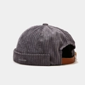 Close-up of dark grey corduroy brimless docker hat showing leather strap and metal buckle - Gray