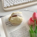 Pale yellow quilted soft case for AirPods with pearl pendant on a minimal desk - Bright yellow