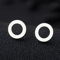 Macro shot of minimalist silver geometric round stud earrings on a dark textured surface - Hollow Round / Silver