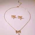 Golden bow jewelry set featuring white pearl pendants on necklace and matching stud earrings - Three-Piece Set / Gold