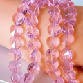 Macro detail of faceted pink-purple crystal heart beads with geometric precision cuts - Pink