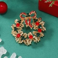 Détail de la broche couronne de Noël avec cristaux étincelants rouges et verts - Or KC