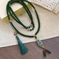 Detail of dark green beaded necklace with enamel pendant and elegant silk tassel - Dark Green