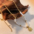 Vintage Goldkette mit Perlen und Sonnenanhänger auf rustikalem Holzelement präsentiert - Sonnenanhänger / Gold/Weiß