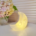 Cartoon moon night light in warm yellow glow with a smooth rounded silicone finish - Small Cheese Moon White