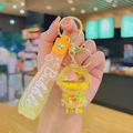 Llavero de astronauta con arena movediza amarilla y anillo dorado en primer plano - Astronauta de Arena Movediza Amarillo