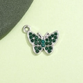Vista macro di un ciondolo a farfalla d'argento con strass verdi brillanti incastonati - Farfalla Verde Pavone Placcata Argento UV