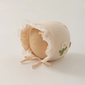 Detail der Baby-Baumwollhaube mit Spitzenbesatz und gestrickter Blumenapplikation - 35-45cm 0-12 Monate / Hellbeige