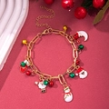 Close-up of gold Christmas charm bracelet with Santa, bell and snowflake on red background - D1148 (Santa and Moon)
