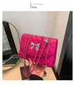 Detailed view of pink quilted handbag with silver bow detail and metal chain strap - Rose Red