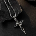 Gros plan d'un collier en acier titane argenté avec pendentif flèche croisée sur roche - Collier Croix Flèche (L329-A)