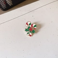 Detail of Christmas candy cane brooch with green holly leaves and red berries on white background - Candy Cane