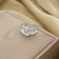 Crossed double layer silver ring with cubic zirconia on a beige jewelry display box - Double C Cross Style (649) / Silver