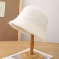 Detailed close-up of fluffy white wool blend bucket hat on a wooden display stand - Beige