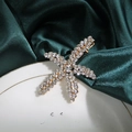Pinza de estrella de mar dorada con diamantes de imitación sobre fondo de seda verde - Pinza de pico de pato de estrella de mar con diamantes de imitación