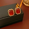 Vue macro de boucles d'oreilles vintage dorées avec pierre en résine rouge sur boîte noire - Or avec Café (Tige en Argent)
