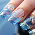 Macro detail of translucent blue gradient press-on nails with luxury gold foil marble texture - Blue Gold Foil Marble Style (CW173)