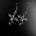 Macro shot of gothic silver dragon earrings featuring intricate wings and long tail - Flying Dragon