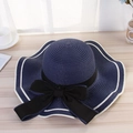 Detalle de un sombrero de paja azul oscuro con lazo negro grande y borde de rayas blancas - Lazo de Ola Azul Marino