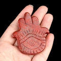 Natural red jasper crystal Hamsa hand carving with evil eye palm detail held in hand - Red Jasper