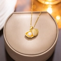 Collana a conchiglia dorata con perle e strass su portagioie in luce calda soffusa - Stile Conchiglia Perla (8834) / Oro