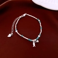 Macro shot of silver beaded bracelet with ocean blue gems and white pearls on red silk - Sea Blue Faceted Bead Style / Silver/Blue