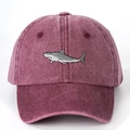 Close-up of a burgundy washed cotton baseball cap featuring detailed shark embroidery - Burgundy
