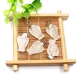 Five rose quartz crystal angel wing pendants with silver clasps on a bamboo tray - White Crystal