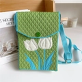 Detail of green knit phone bag featuring white tulip pattern and blue braided strap - Tulip Green