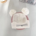 Detailaufnahme der Winterstrickmütze mit flauschigen weißen Bommeln und Katzenstickerei - 3-8 Jahre / Weiß