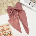 Detail of elegant dusty pink satin bow hair clip with long ribbons on lace background - Pink