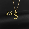 Detailed close-up of golden letter S pendant necklace and matching stud earrings set - Letter S / Gold
