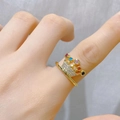 Detail eines goldenen Kronenrings mit bunten Edelsteinen und kleinen Diamanten am Finger - Mehrfarbiger Stein Krone Stil (C)