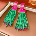Detail of pink geometric studs and green beaded long fringe tassels in a jewelry box - Fuchsia/Green (Silver Pin)