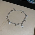 Detail view of double-layer silver bracelet featuring zircon heart charms and round beads - Silver