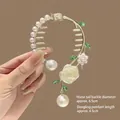 Détail de pince à cheveux muguet avec rose blanche, feuilles vertes et perle pendante - Pendentif Rose Blanche