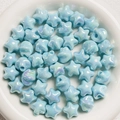 Blue star-shaped iridescent beads in a white bowl for DIY jewelry and crafts - Light Blue