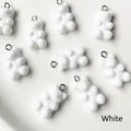 Vue macro de breloques ours en résine blanche brillante avec boucles pour bijoux DIY - Blanc