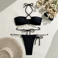 Détail d'un bikini noir côtelé avec décorations de perles et de coquillages sur tapis - S / Noir