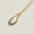 Primer plano de collar vintage con colgante ovalado de circón y halo de cristales finos - Blanco
