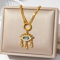 Gold evil eye necklace with blue stones and teardrop crystals on jewelry box - Evil Eye Water Drop Tassel Style (N2953)