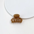 Primo piano di una piccola molletta per capelli marrone lucida su superficie bianca - Mini Molletta Gelatina - Caffè Chiaro Zucca
