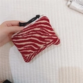 Macro detail of zebra pattern fabric pouch with woven texture and zipper closure - Chenille Red